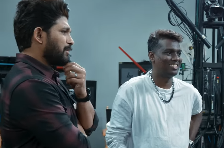 Two men engaged in conversation during a behind-the-scenes moment, focusing on the creative process in a studio setting.
